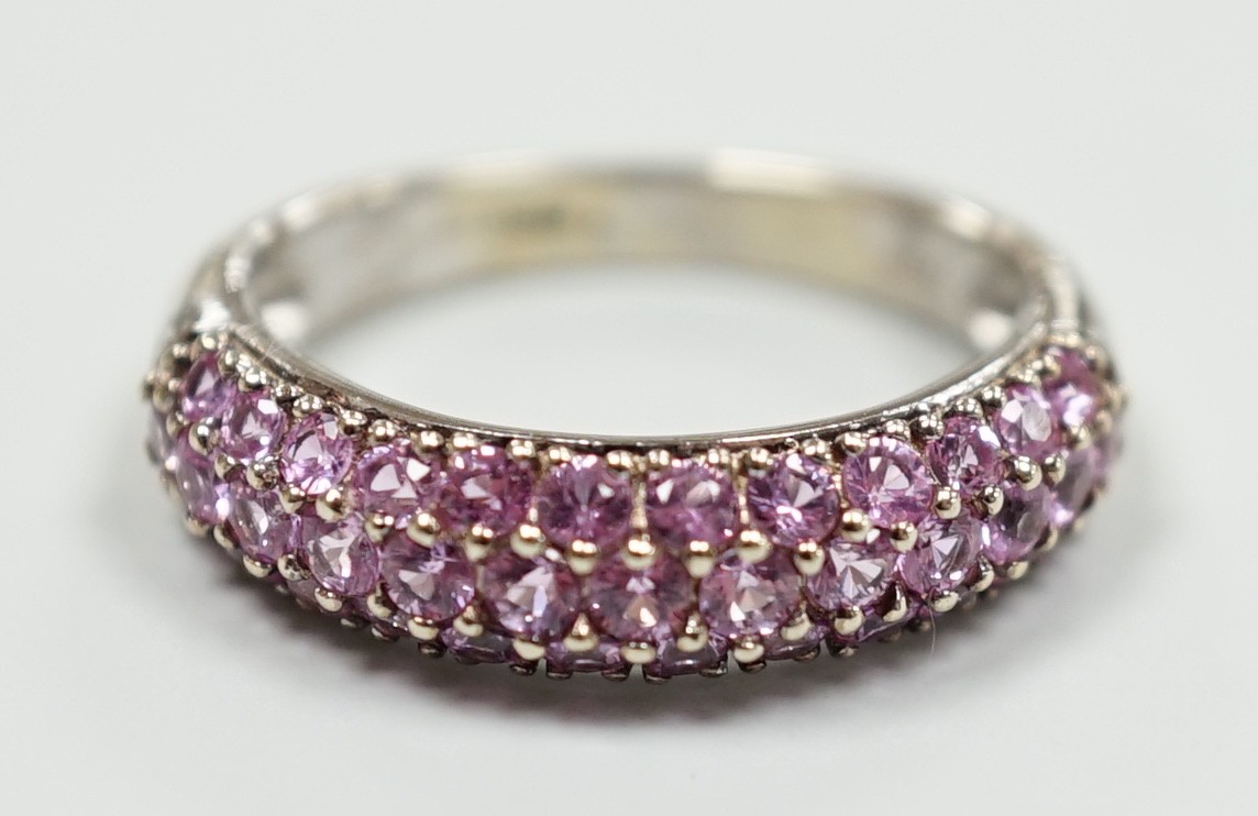 A modern 18ct white gold and pink stone cluster set half hoop ring, size J, gross weight 4.2 grams.